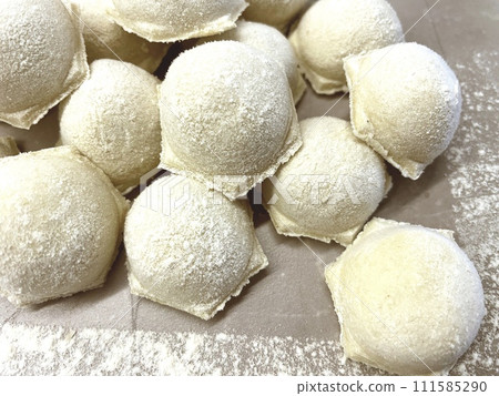 Dumplings made of dough and minced meat are stuck on the board 111585290