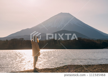 A girl greets the sunrise from the foot of Mt. Fuji 111585468