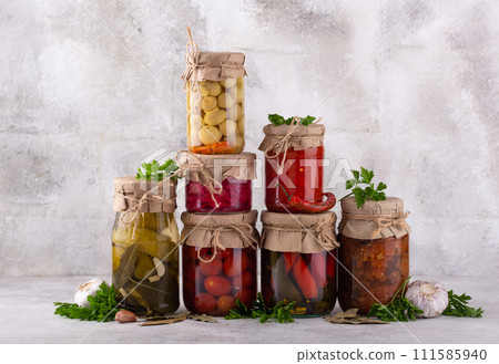Pickled vegetables in glass jars. 111585940