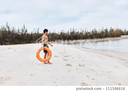Beach Lifeguard: An Asian Man, the Rescuer of Summer, Embracing Safety and Joy amidst the Blue Ocean waves. Beach Lifeguard: An Asian Man, the Rescuer of Summer, Embracing Safety and Joy amidst the Blue Ocean waves. 111586818