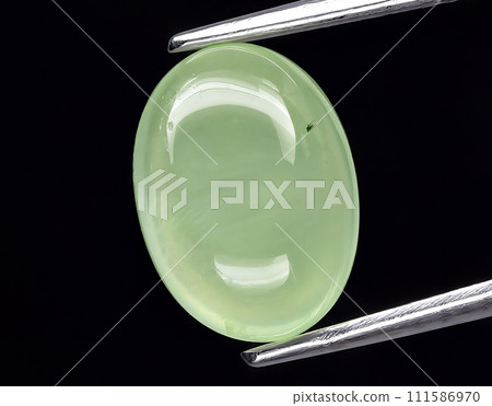 natural green prehnite gem on the background 111586970
