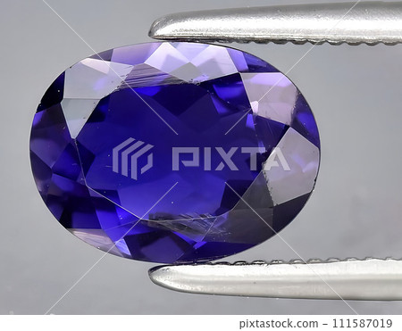 natural blue violet iolite gem on the background 111587019