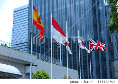 Flags of various countries (Spain, England, etc.) flying on the hotel entrance pole 111588702