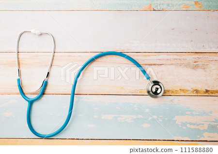 Top view blue medical stethoscope on wooden background with copy space for you text, Doctor equipment, healthcare and medical, Doctor Day and World cancer day Concept Top view blue medical stethoscope on wooden background with copy space for you text, Doctor equipment, healthcare and medical, Doctor Day and World cancer day Concept 111588880