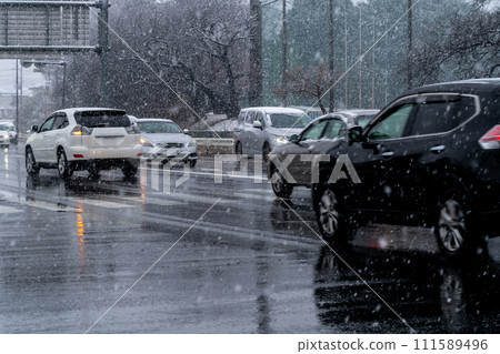Traffic on a snowy evening Main road intersection c-1 Traffic on a snowy evening Main road intersection c-1 111589496
