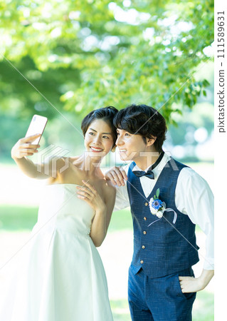 Bride and groom taking photos with smartphone 111589631