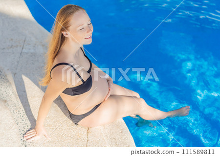 Radiant and relaxed, a pregnant woman finds serenity while enjoying the refreshing embrace of the pool, embracing moments of buoyant joy during pregnancy 111589811