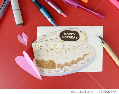 Cake-shaped birthday card and pens and markers 111590172