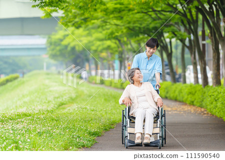 Senior woman and carer in wheelchair 111590540