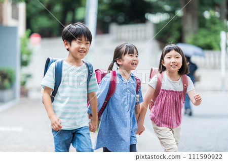 Elementary school students go to school with their friends. 111590922