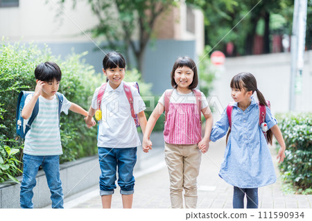 Elementary school students go to school with their friends. 111590934