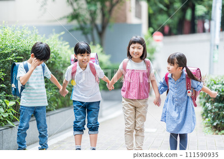 Elementary school students go to school with their friends. 111590935