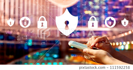Cyber security theme with person using a smartphone in city at night 111592258
