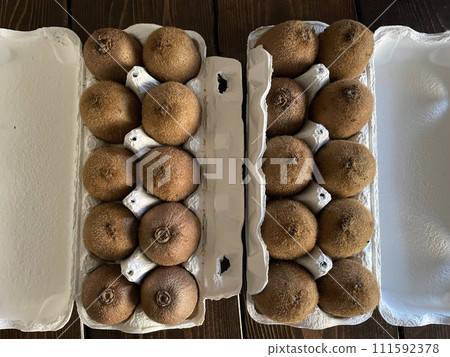 Kiwifruit arranged in an egg carton; fresh green fruit. 111592378