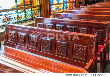 Empty wooden church benches of a Christian church. Blurry alter in the background. Selective focus. Concept of church service or empty churches. Empty wooden church benches of a Christian church. Blurry alter in the background. Selective focus. Concept of church service or empty churches. 111593585