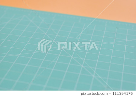 green cutting mat on orange background, object tool for design 111594176