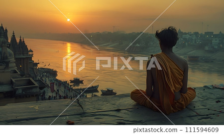 An old yogi was meditating on the bank of the Ganges River. It was quiet amidst the morning sunshine. Behind him is the view of Varanasi. It is a symbol of peace, tranquility and faith in Hinduism. An old yogi was meditating on the bank of the Ganges River. It was quiet amidst the morning sunshine. Behind him is the view of Varanasi. It is a symbol of peace, tranquility and faith in Hinduism. 111594609