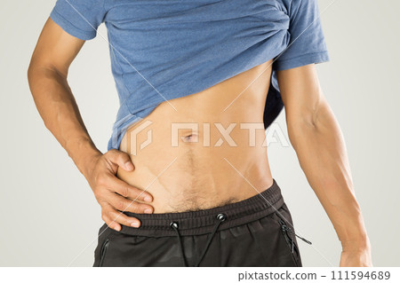 A man pulled up his shirt to reveal his belly. A man pulled up his shirt to reveal his belly. 111594689