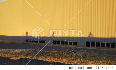 夕陽照耀下的建築物上投下孩子的影子 111594882