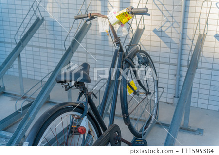 Abandoned bicycle with warning for removal Abandoned bicycle with warning for removal 111595384