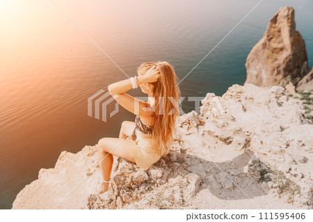 Woman travel sea. Happy tourist enjoy taking picture outdoors for memories. Woman traveler looks at the edge of the cliff on the sea bay of mountains, sharing travel adventure journey Woman travel sea. Happy tourist enjoy taking picture outdoors for memories. Woman traveler looks at the edge of the cliff on the sea bay of mountains, sharing travel adventure journey 111595406