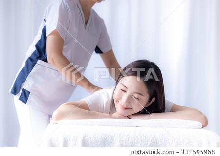 Young woman receiving chiropractic treatment and her teacher 111595968