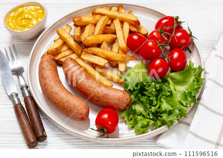 sausages with potato, lettuce, tomatoes, top view sausages with potato, lettuce, tomatoes, top view 111596516