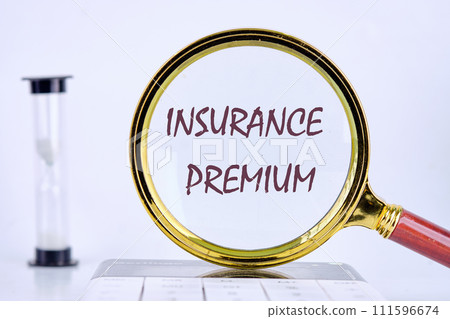 Business concept. text INSURANCE PREMIUM written through a magnifying glass on a gray background. Business concept 111596674
