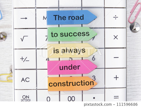 The road to success is always under construction text the phrase is written on arrow-shaped stickers 111596686