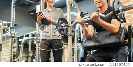 Male and female trainers training at the gym Male and female trainers training at the gym 111597463
