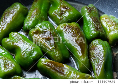 A cooking scene where stuffed peppers are baked in a frying pan. A cooking scene where stuffed peppers are baked in a frying pan. 111597685