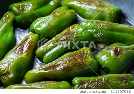 A cooking scene where stuffed peppers are baked in a frying pan. A cooking scene where stuffed peppers are baked in a frying pan. 111597688