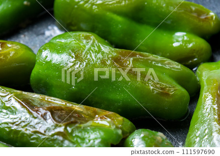 A cooking scene where stuffed peppers are baked in a frying pan. 111597690