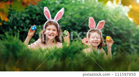 children with painting eggs outdoors 111597850