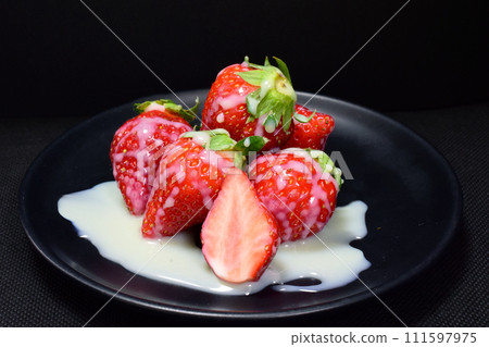 Bright red fresh strawberries topped with sweet condensed milk 111597975
