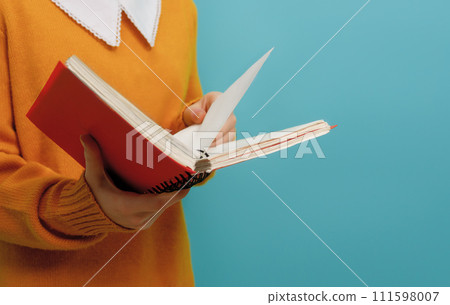 Girl with book on background of bright teal wall Girl with book on background of bright teal wall 111598007
