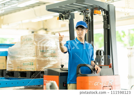 A man driving a forklift in a warehouse 111598123