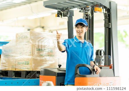 A man driving a forklift in a warehouse 111598124