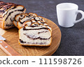 Fresh homemade bun with poppy seeds and mug of milk at dark background, breakfast concept 111598726