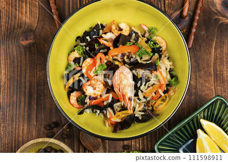 Plate of shrimp fried rice on a wooden table. 111598911