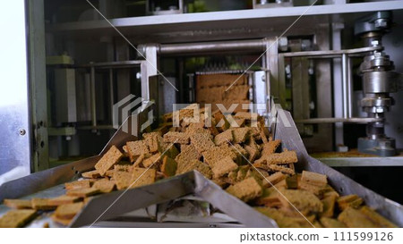 Croutons on the conveyor. Automated line for the production of rusks from bread. Conveyor line machine 111599126