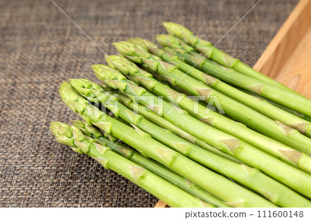 Green asparagus on brown linen background 111600148
