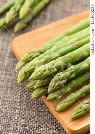 Green asparagus on brown linen background 111600220