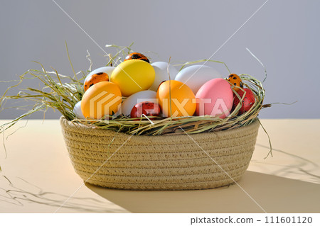 Easter colored eggs in a wicker basket. Easter composition. Easter colored eggs in a wicker basket. Easter composition. 111601120
