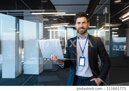 Professional confident male executive with a laptop at a corporate office, exemplifying leadership and success at work. Professional confident male executive with a laptop at a corporate office, exemplifying leadership and success at work. 111601773