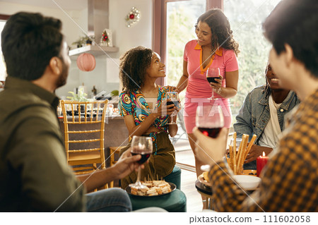 Group of smiling friends enjoying in conversation and drinking wine during Christmas party at home Group of smiling friends enjoying in conversation and drinking wine during Christmas party at home 111602058