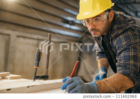 Carpenter man wear gloves during working using tape measure and pencil to make marks piece of wood board for cut on table saw at workshop or woodshop industry, woodwork, Happy Carpenter's Day 111602068