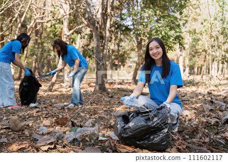 Volunteer collecting plastic trash in the forest. The concept of environmental conservation. Global environmental pollution. Cleaning the forest 111602117