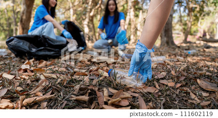 Volunteer collecting plastic trash in the forest. The concept of environmental conservation. Global environmental pollution. Cleaning the forest 111602119