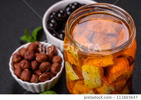 Delicious soft white feta cheese with salt, spices and herbs on a dark concrete background 111603647